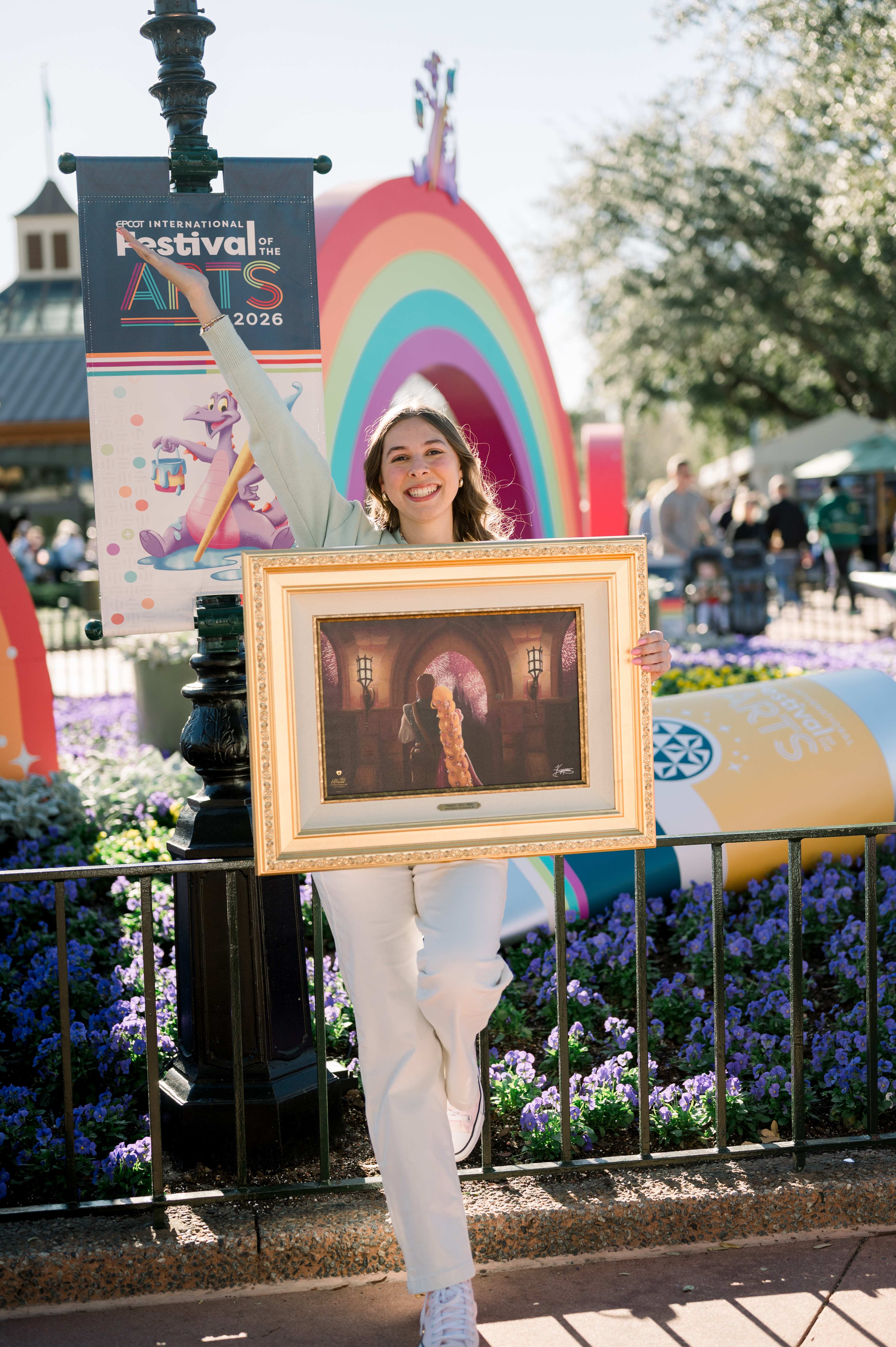 Kyree Tilsher holding her framed painting at EPCOT International Festival of the Arts 2026